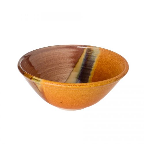 a small, handmade, red and orange salad bowl with flared sides and a variegated blue band across the surface.